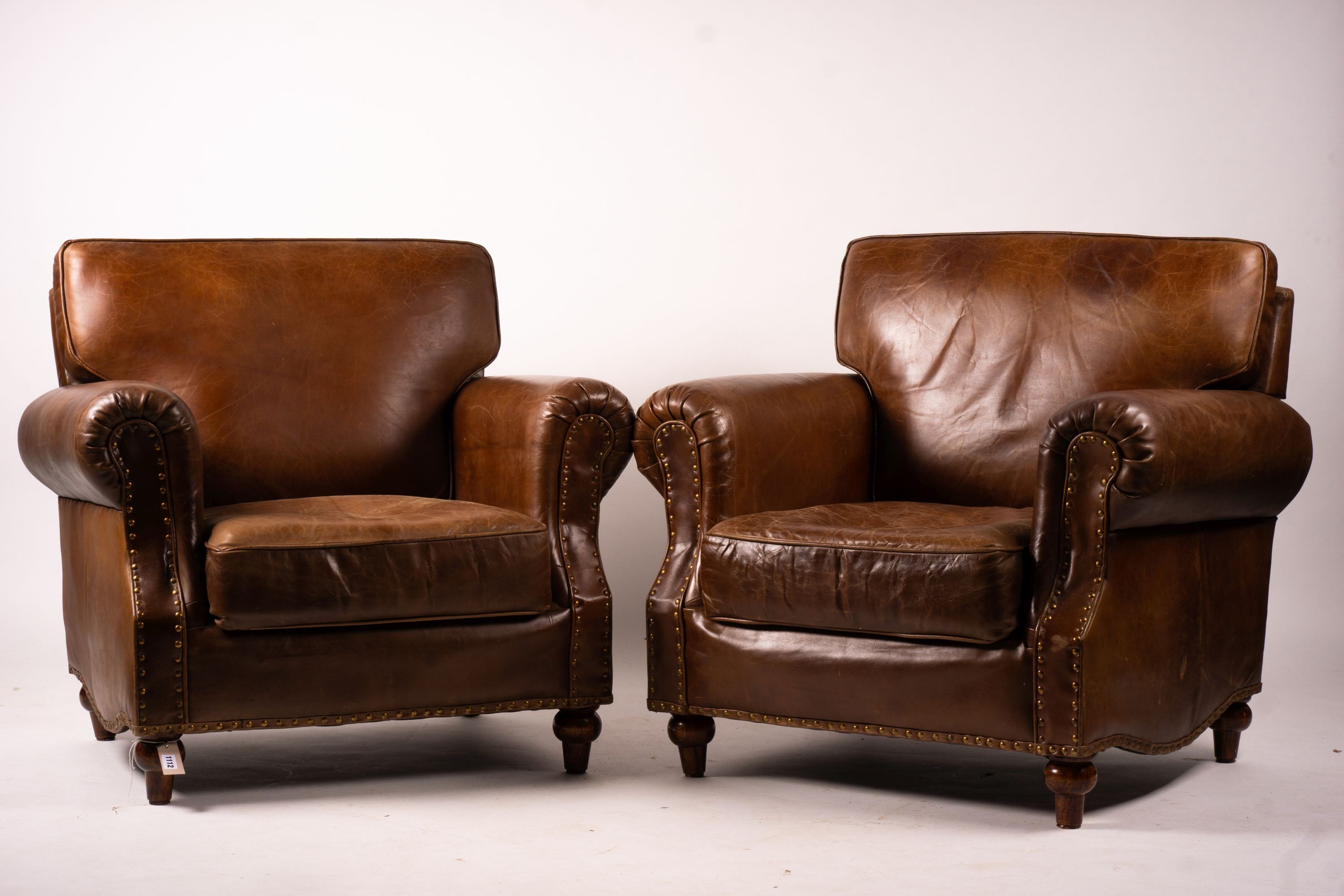 A pair of brown leather club armchairs, width 96cm, depth 80cm, height 90cm